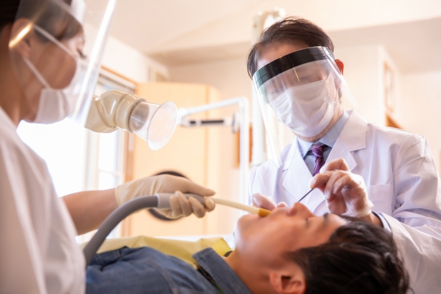 歯医者で治療を受ける男性